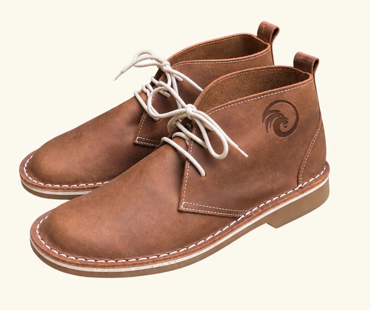 Tan leather chukka boot with a circular eagle emblem debossed into the heel counter