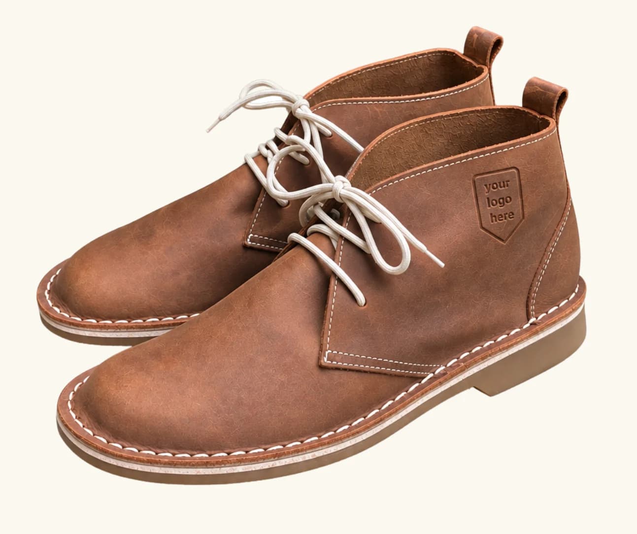 Tan leather chukka boot with a logo debossed into the heel counter